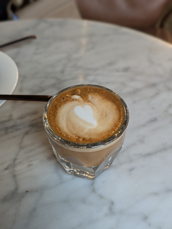 Small latte with heart art on marble table
